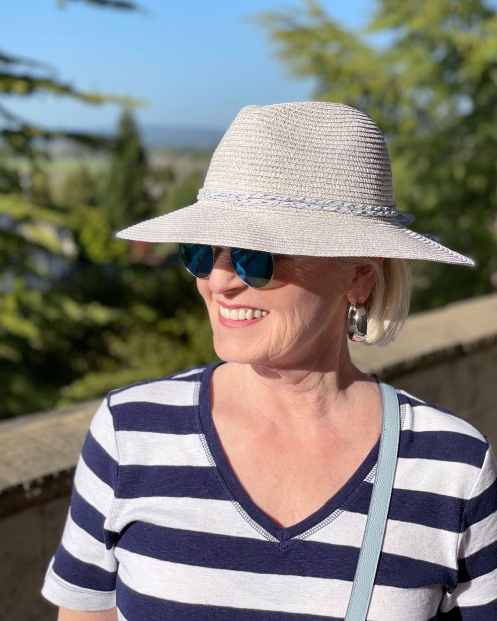woman wearing straw hat and striped dress with sunglasses