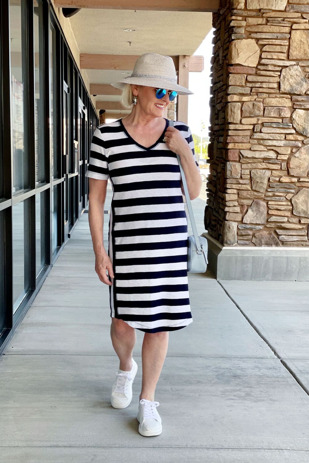 over 50 fashion blogger wearing striped tee dress and straw hat