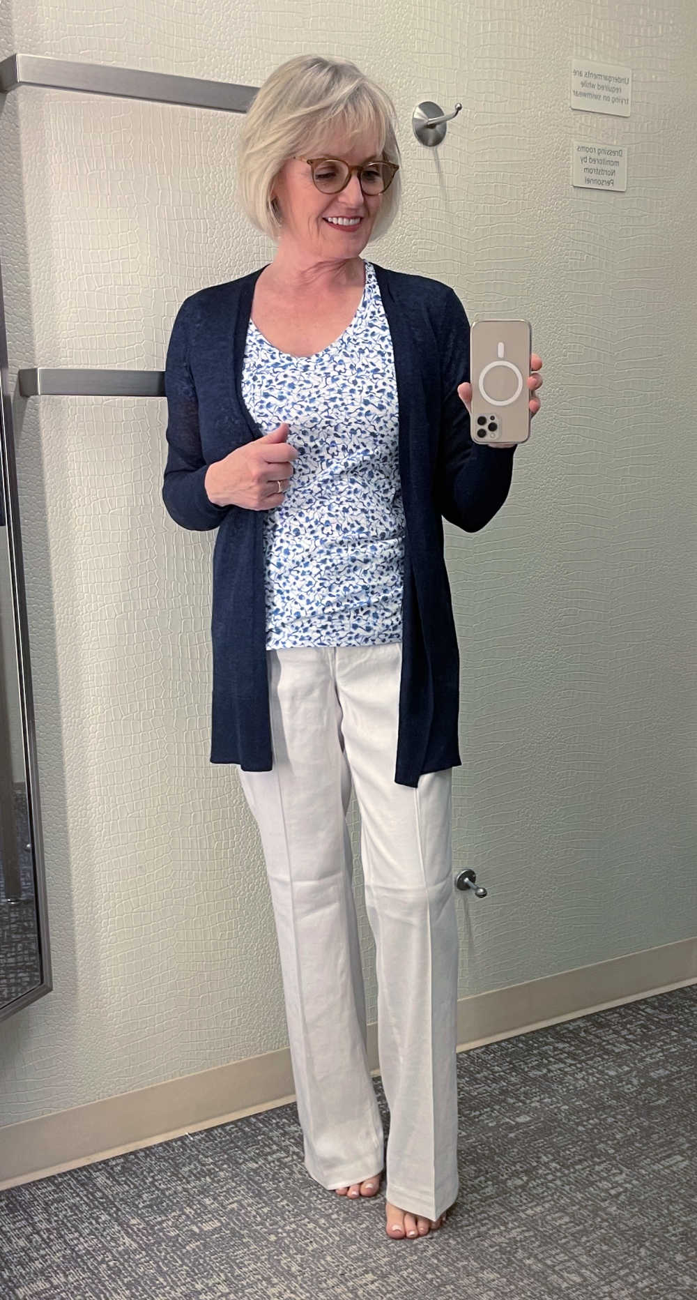 blonde woman wearing white linen pants and navy cardigan
