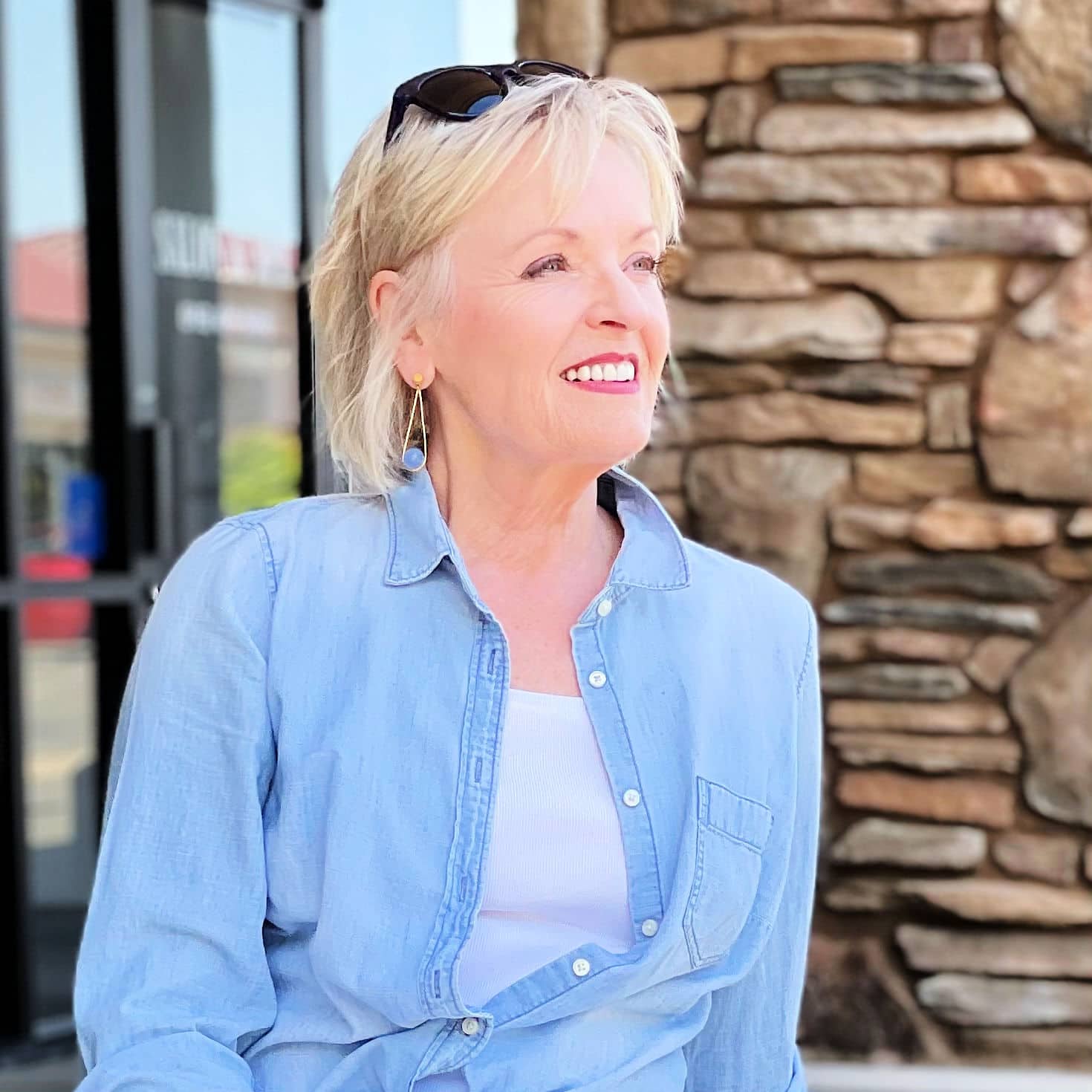 woman wearong chambray shirt and blue stone earrings
