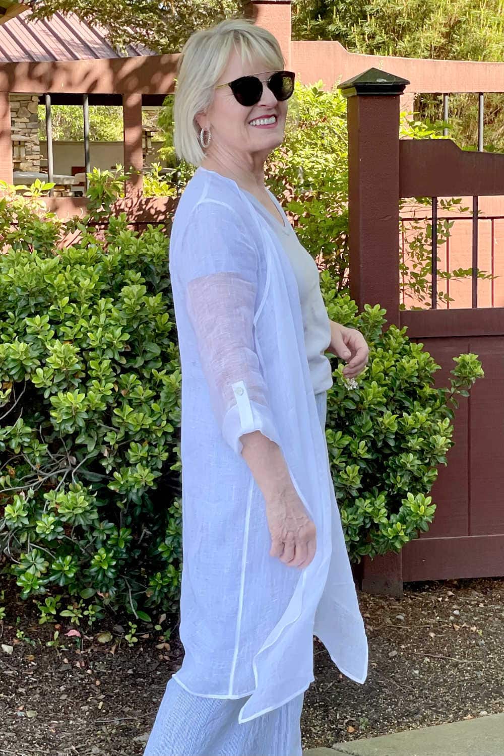 side view of woman showing tab button detail on sleeve of linen topper