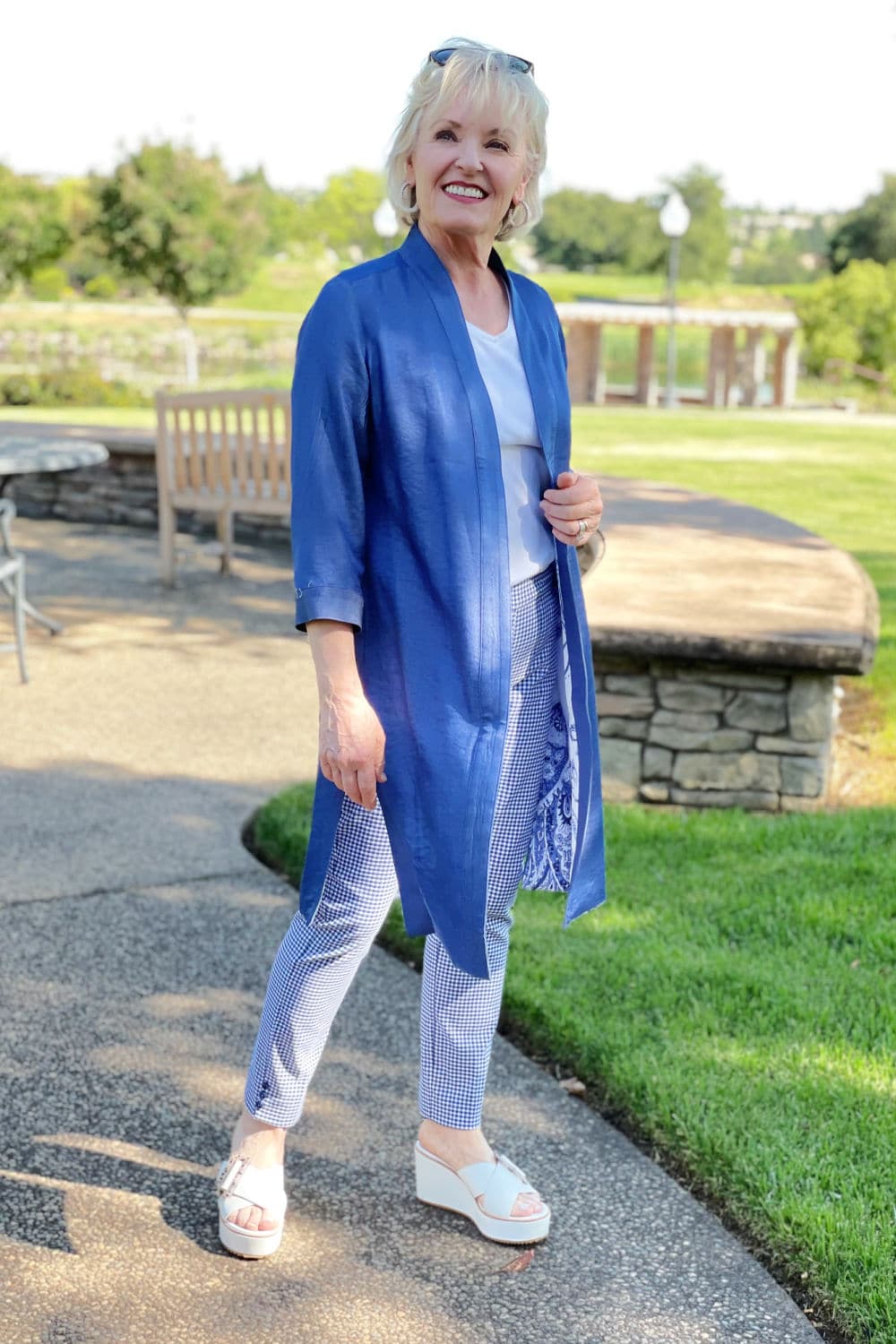 over 50 blogger modeling blue jacket and plain pants in park