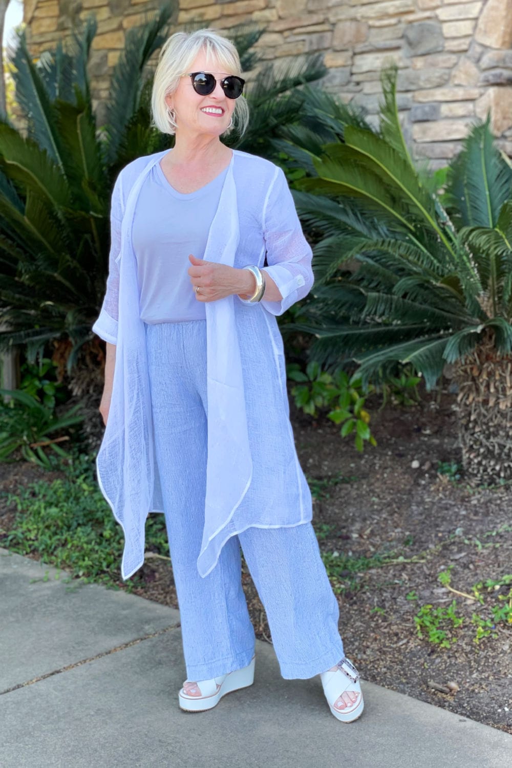over 50 blogger modeling white guaze topper and linen pants