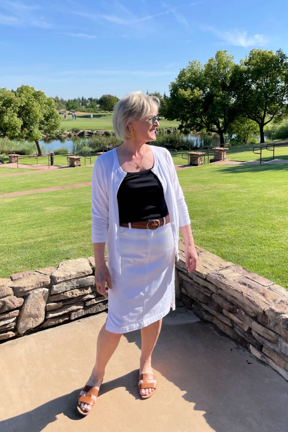woman on gold course wearing white outfit and black top
