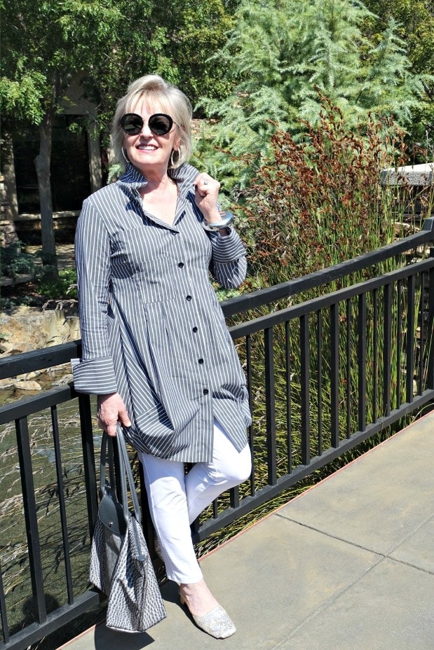 woman wearing black and white striped top with white jeans
