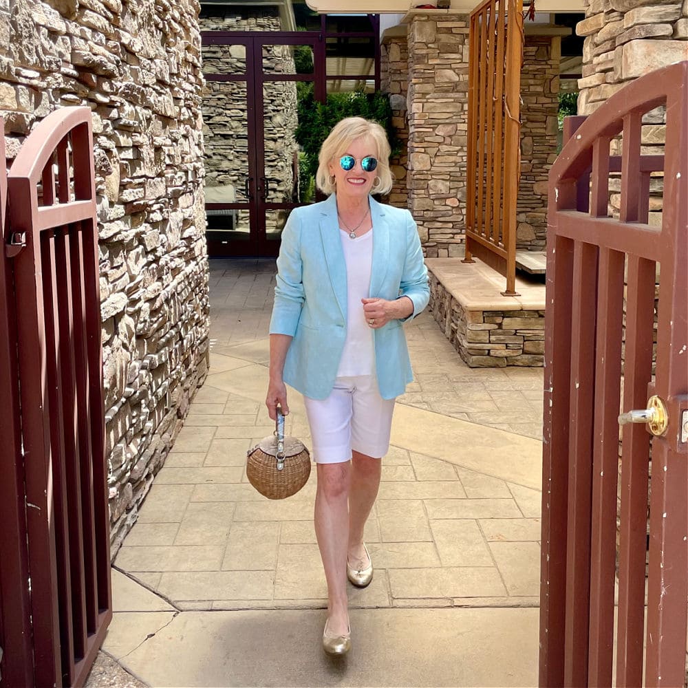 woman walking through gate wearing aqua blazer