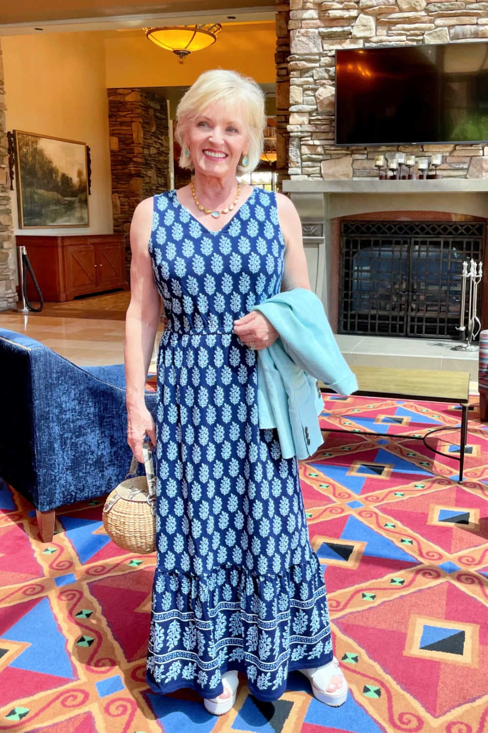 blonde woman stanging in front of fireplace wearing Talbots casual jersey dress and wedge sandals