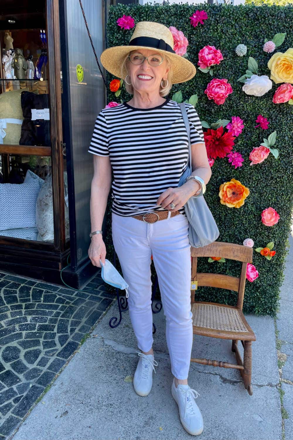 woman wearing whote jeans and strippped tee in front of flower store