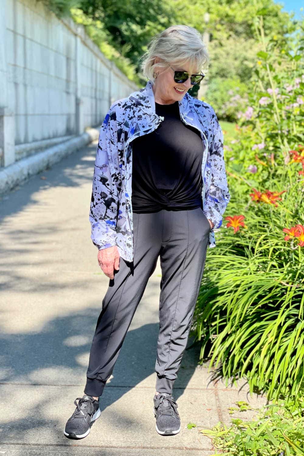 woman on path wearing zip up jacket and joggers