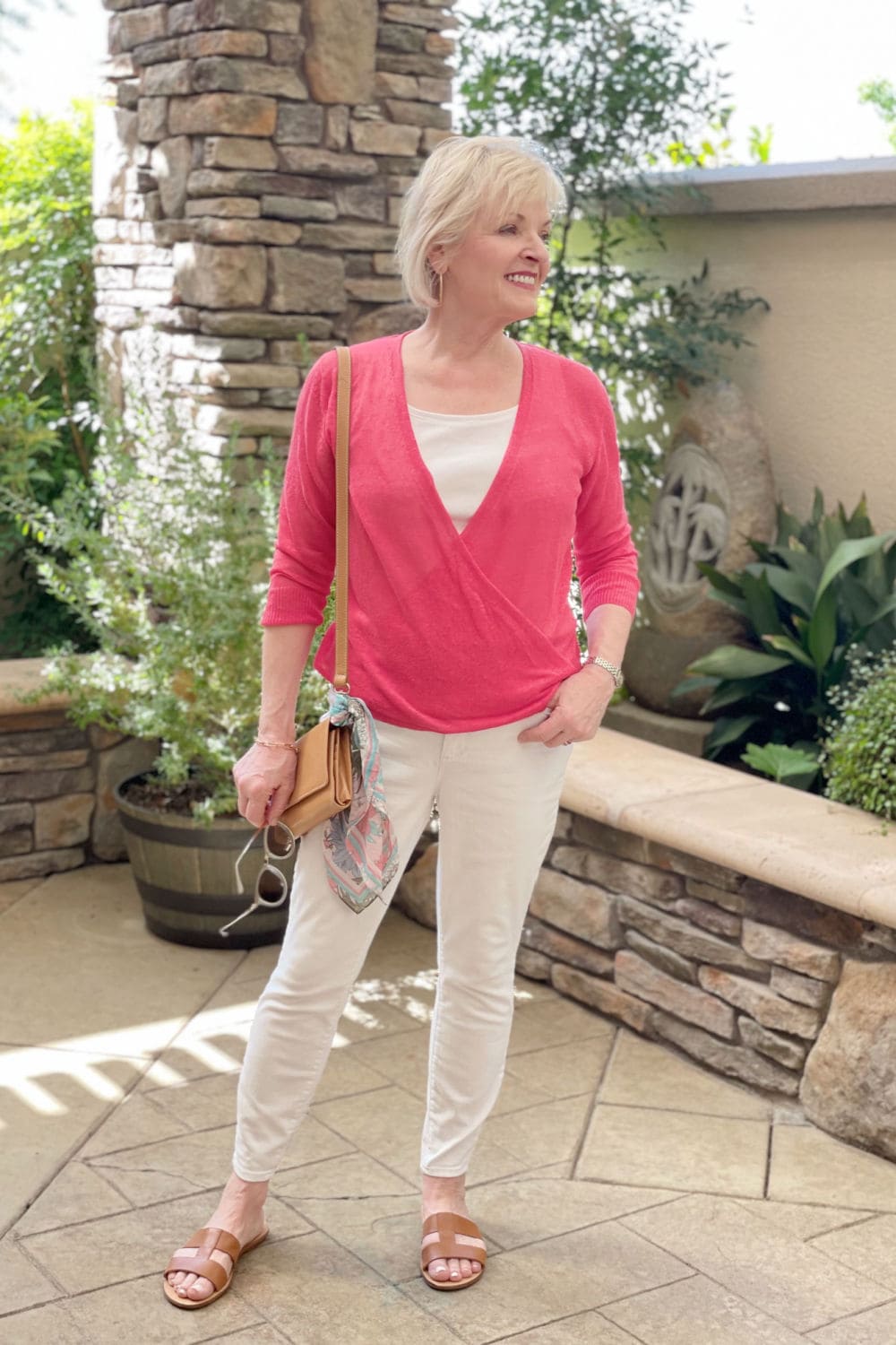 blonde woman wearing white jeans and top with red sweater