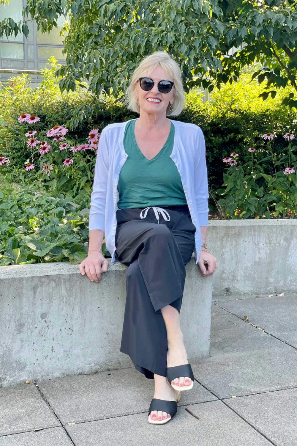 woman sitting on wall wearing black Zella pants with cotton cardigan