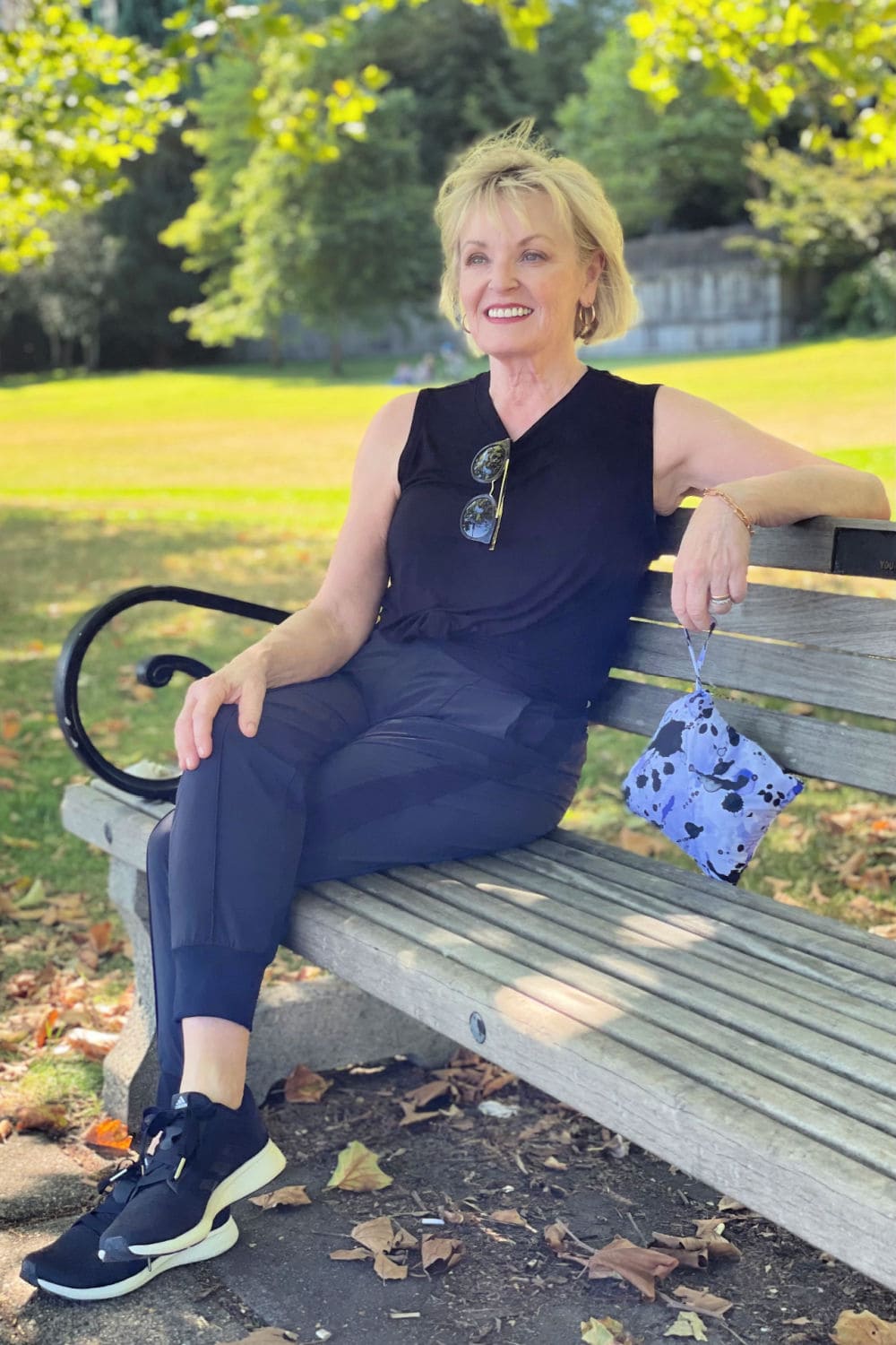 woman sitting on bench wearing black Zella pants and top