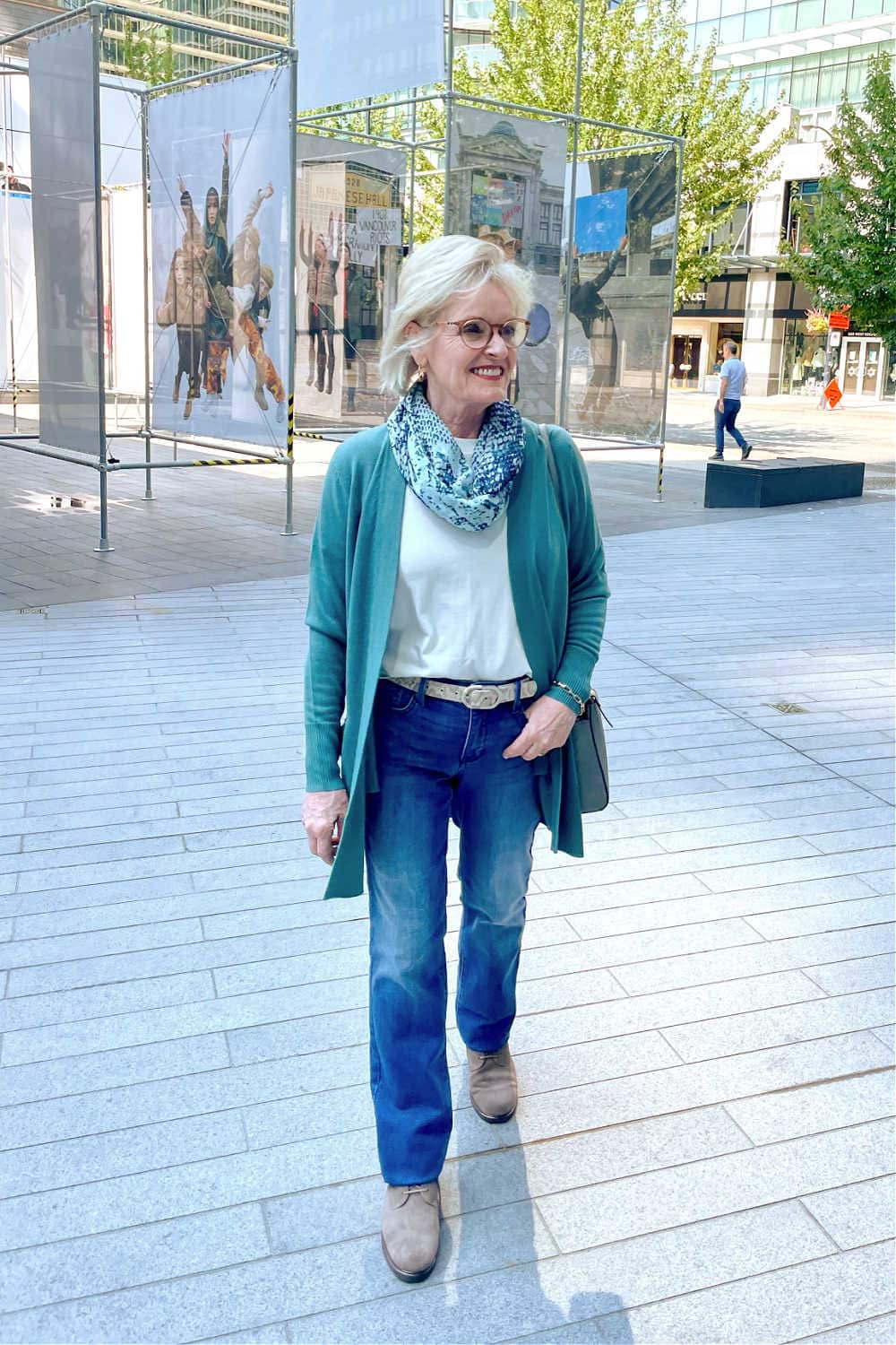 over 50 blogger jennifer connolly wearing nydj and teal cardigan while walking down the sidewalk