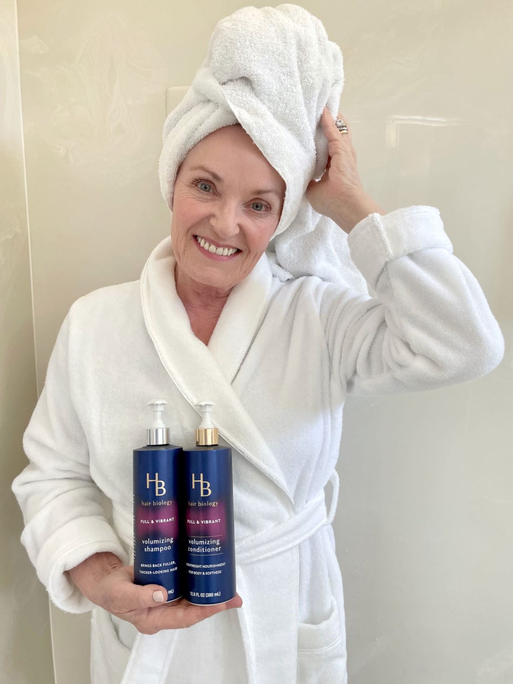 WOMAN HOLDING HAIR BIOLOGY THICKENING SHAMPOO AND CONDITIONER