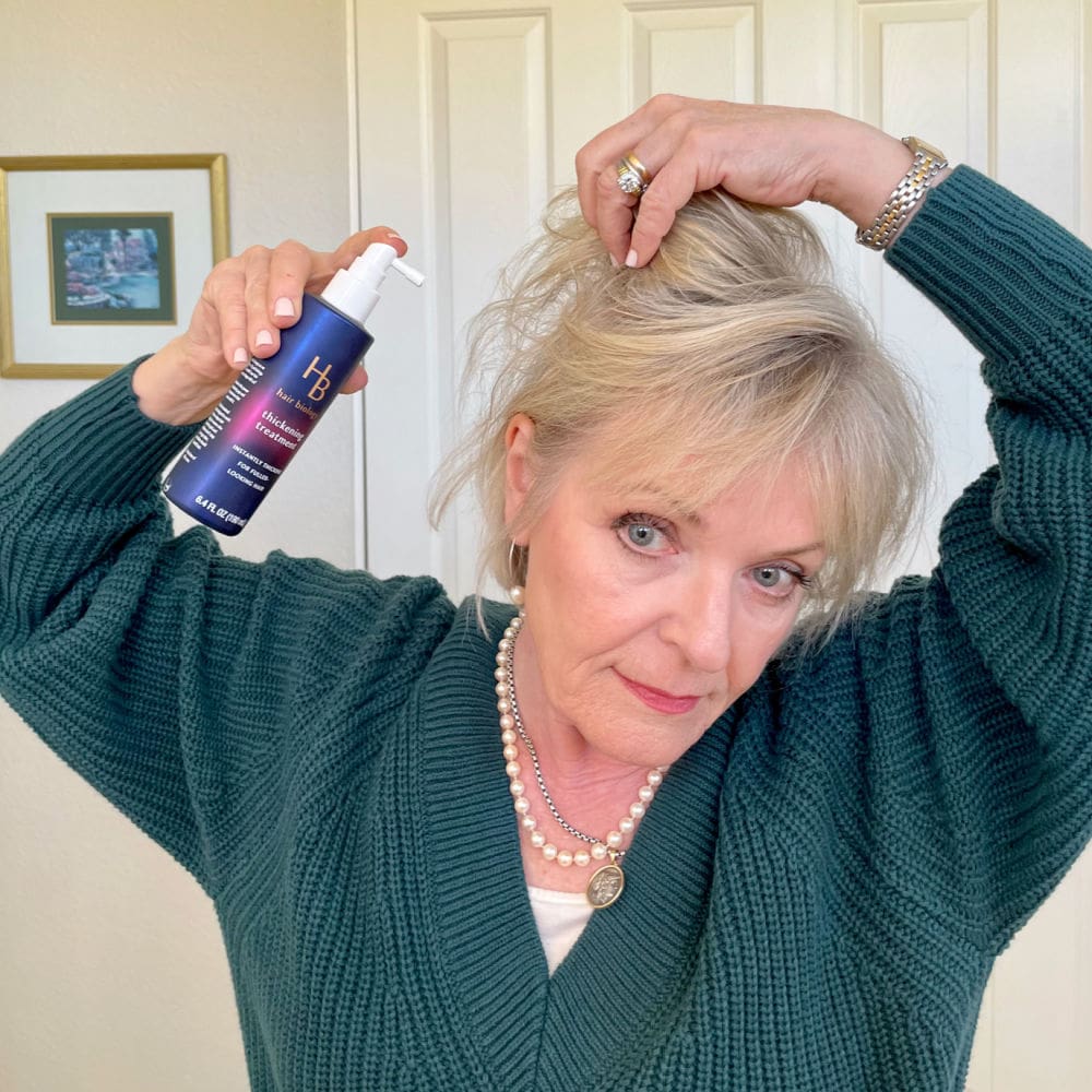 over 50 woman spraying her hair with thickening spray
