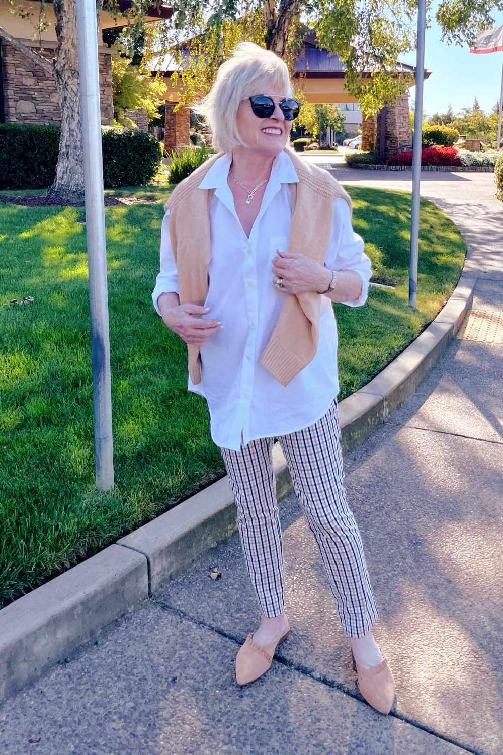 blonde woman wearing white tunic shirt and plaid pants