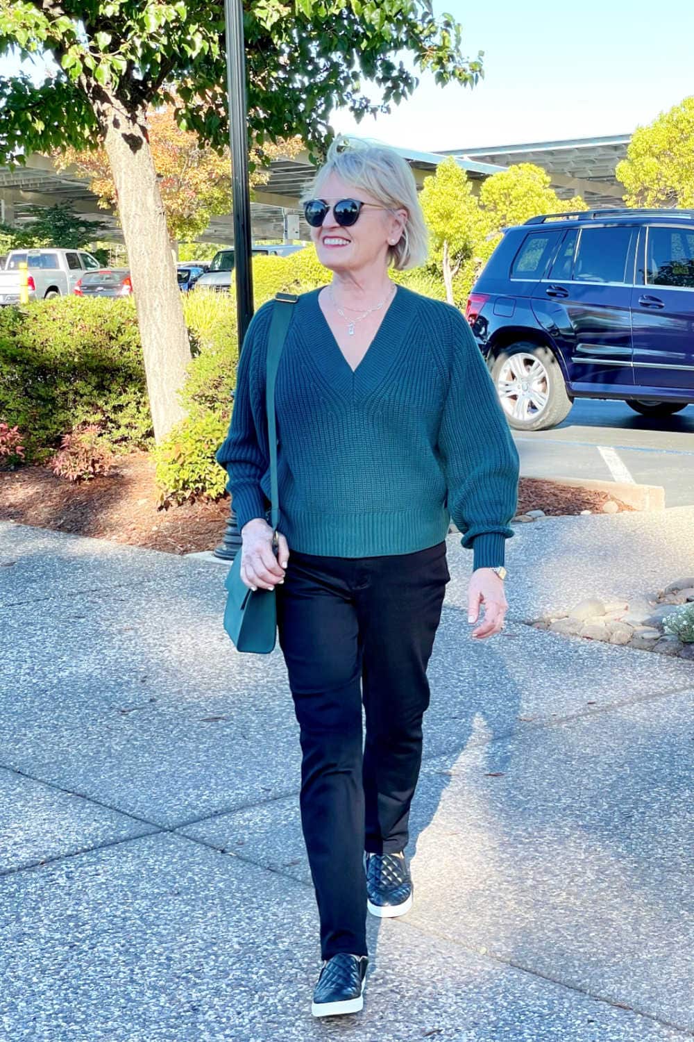 woman in green sweater and black jeans