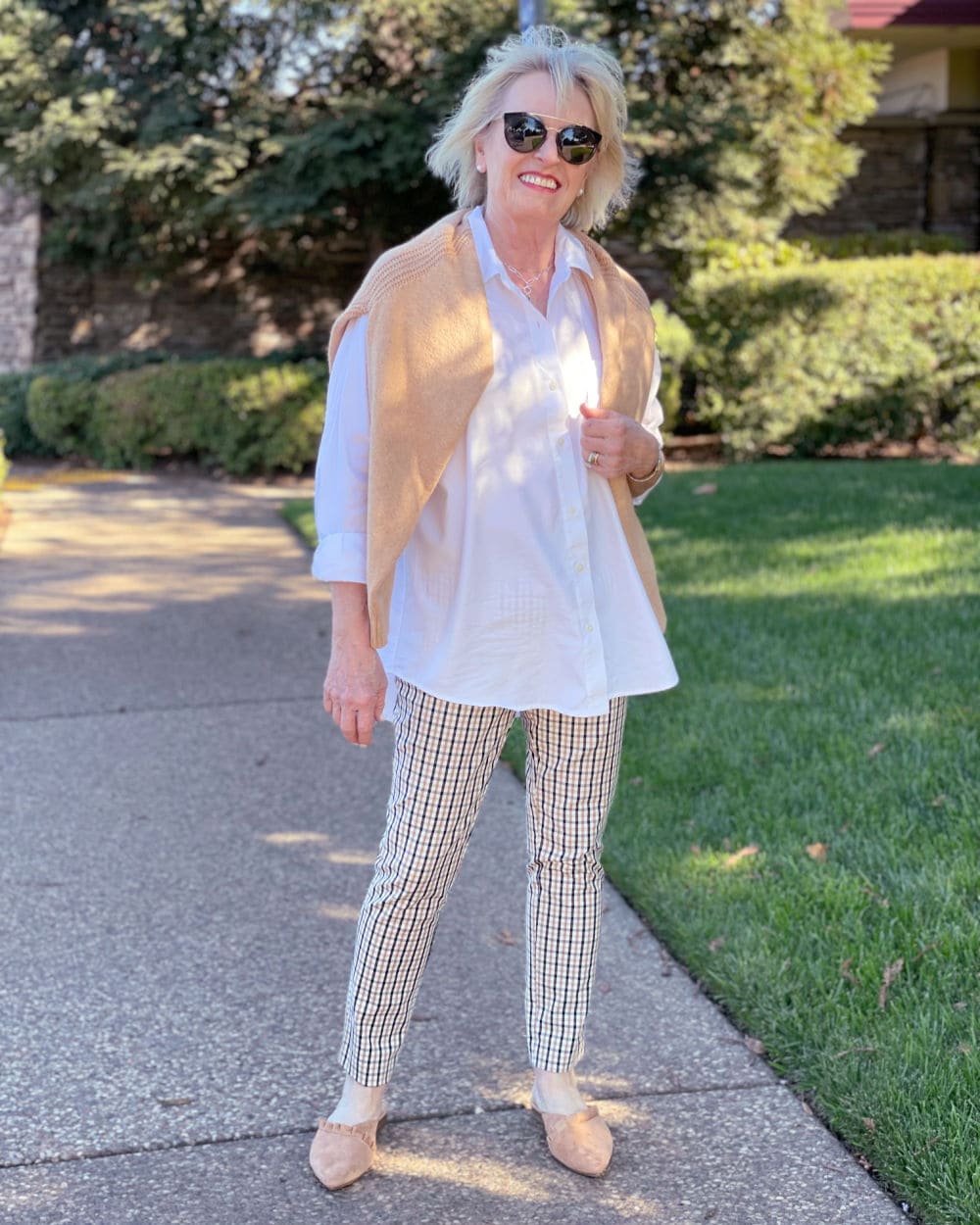 woman wearing white short, plaid pants and ruffled mules