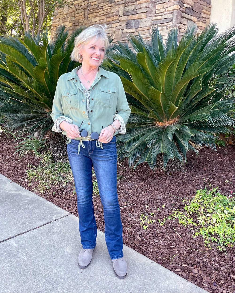 woman walking lightweight fall outfit of green jacket and jeans