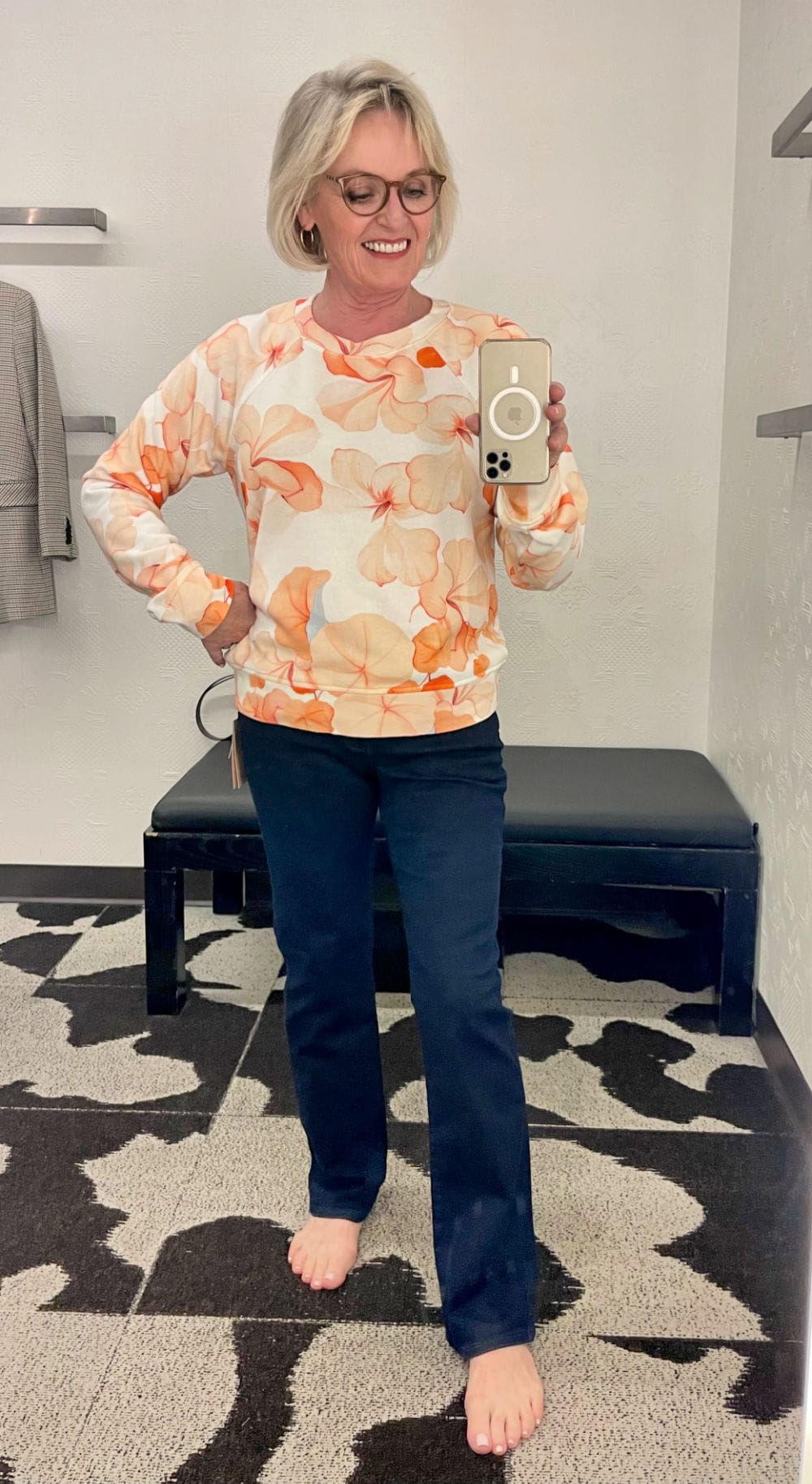 straight jeans and colorful sweatershirt on over 50 blogger in dressing room selfie
