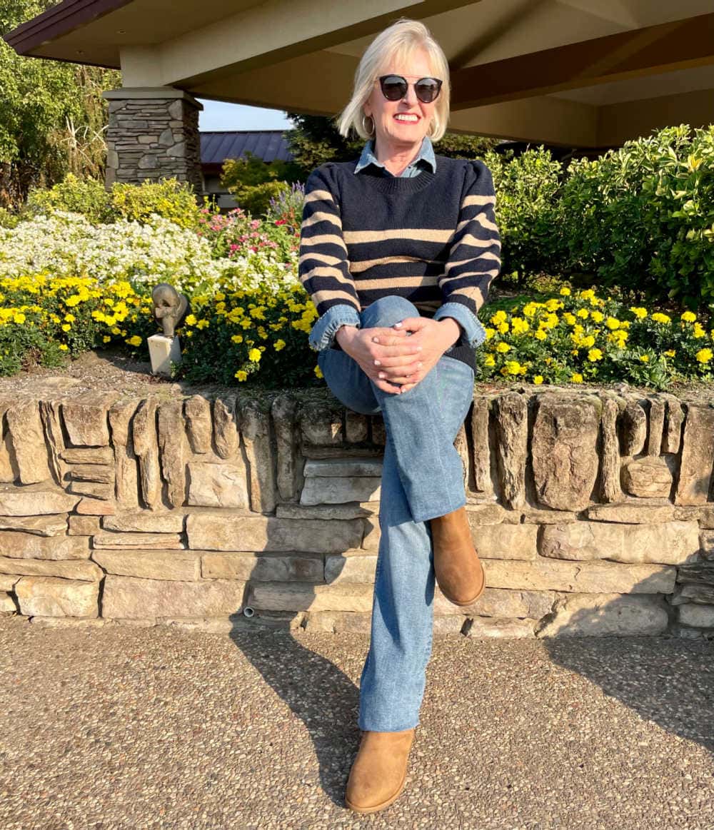 woman sitting on wall wearing free assembly sweater and jeans from walmart