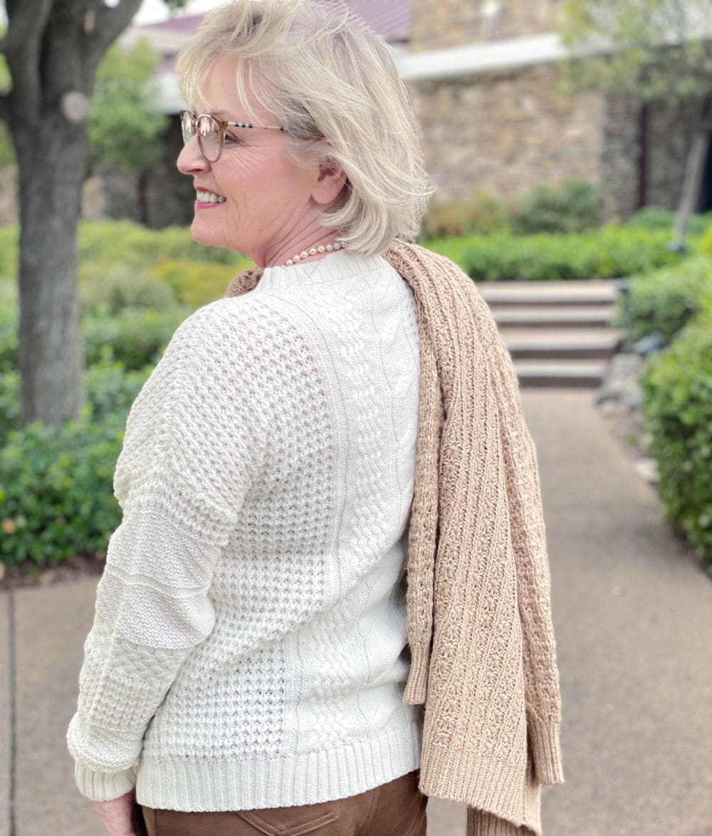woman showing layers of textured neutral sweaters