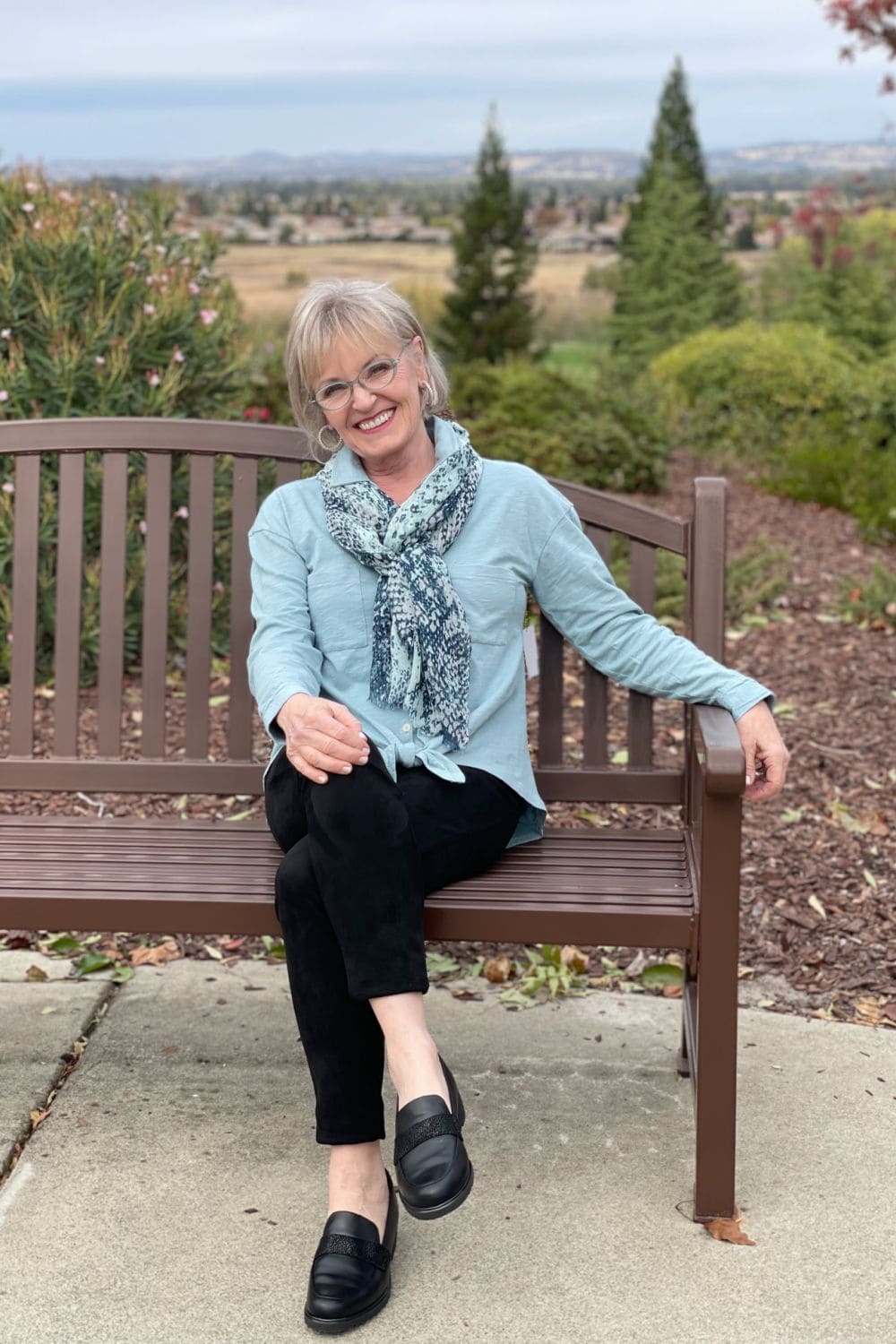 jennifer connoly of a well styled life sitting on bench wearing cozy leggings, and comfy loafers