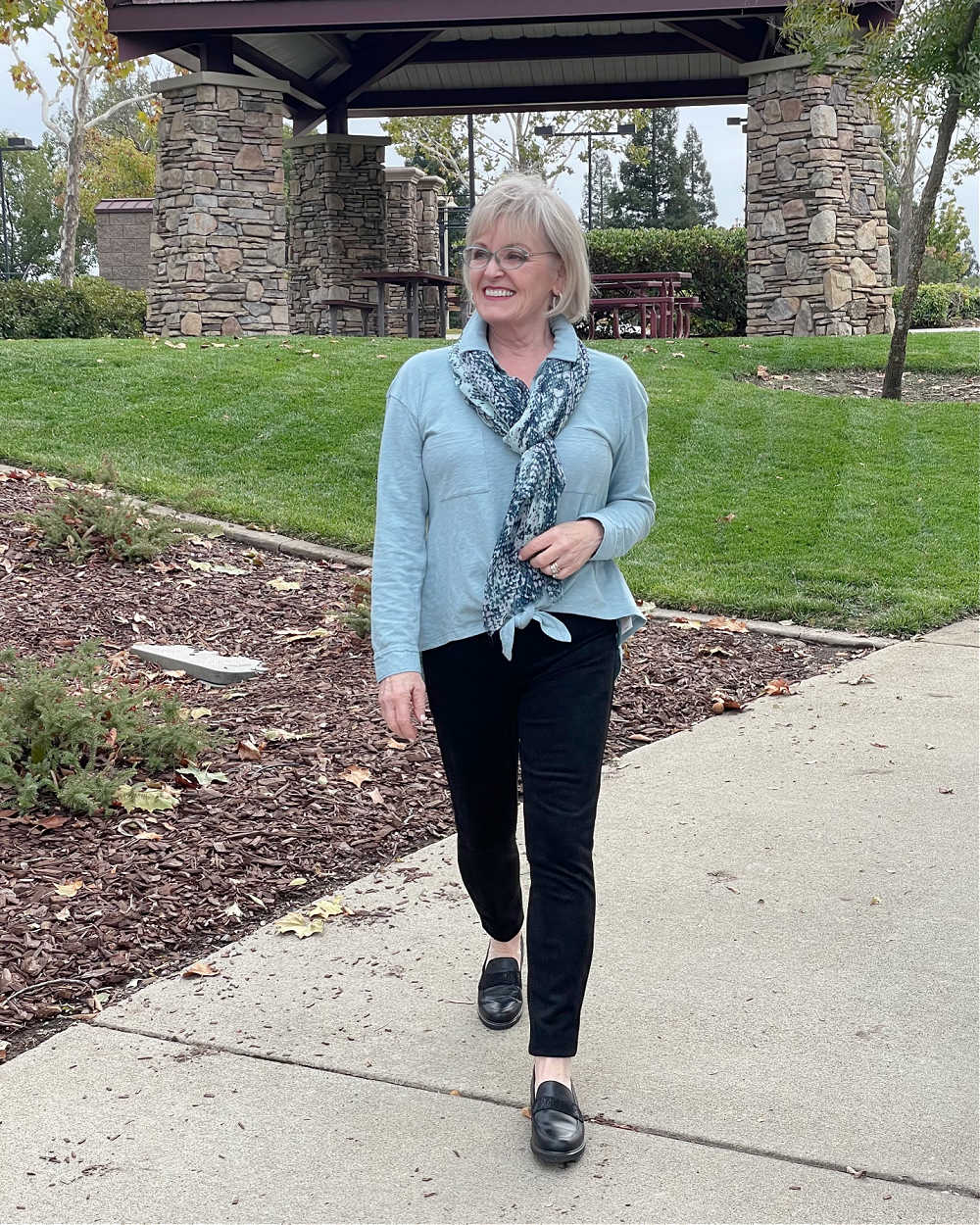 woman walkiing in loafers, cozy leggings and collared shirt