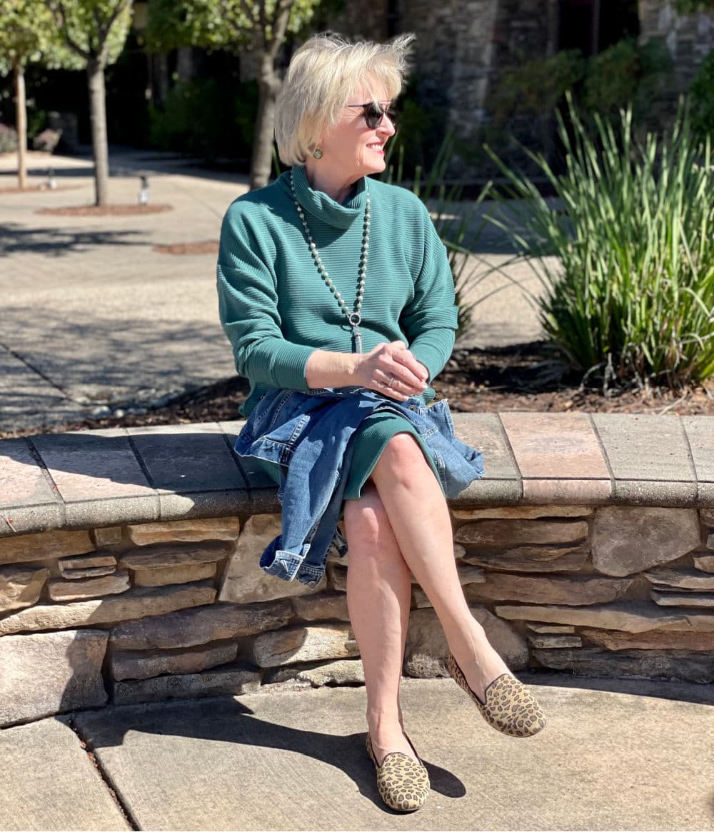 woman sitting on wall wearing animal print rothy's shoes and target dress