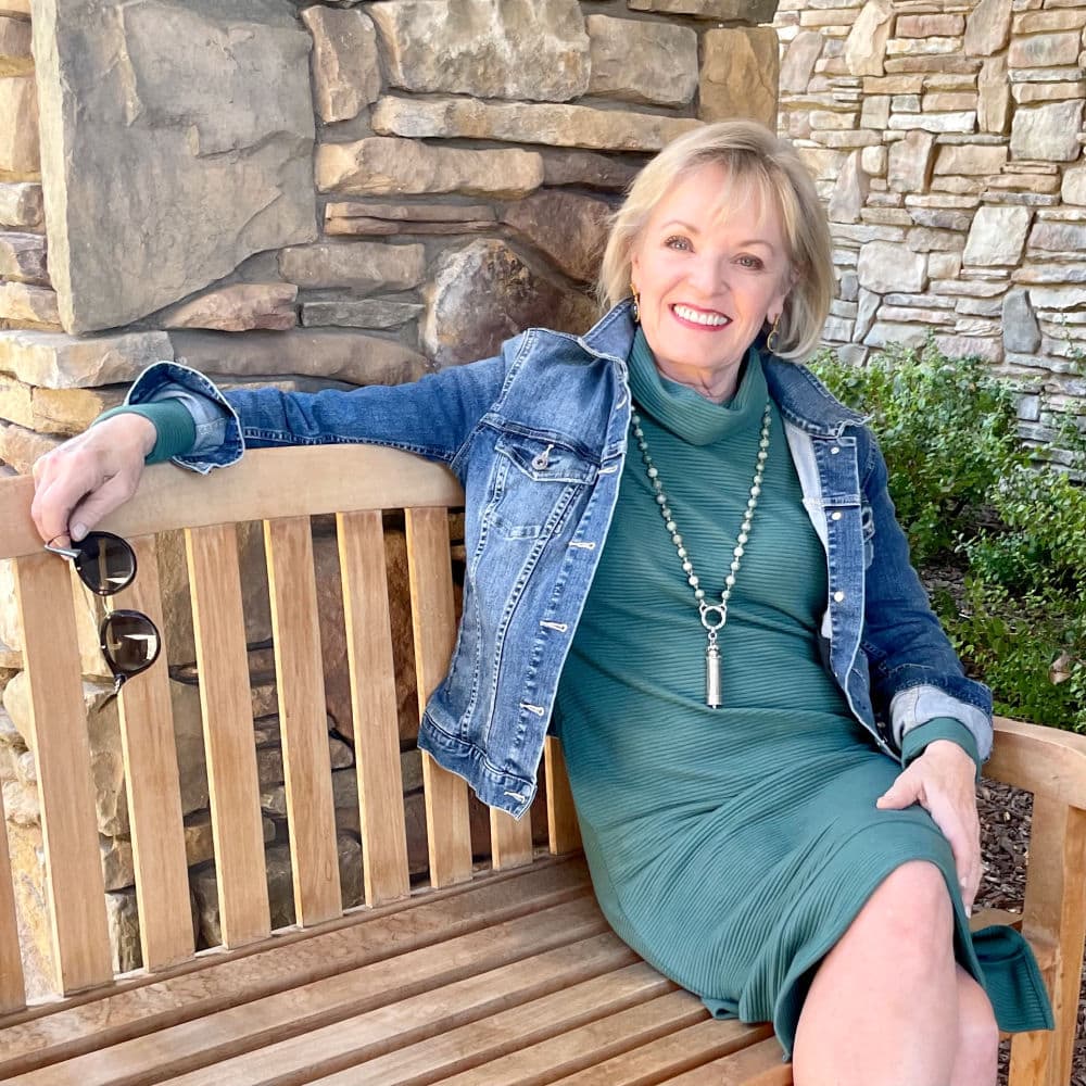 woman sitting on bench smiling into camera
