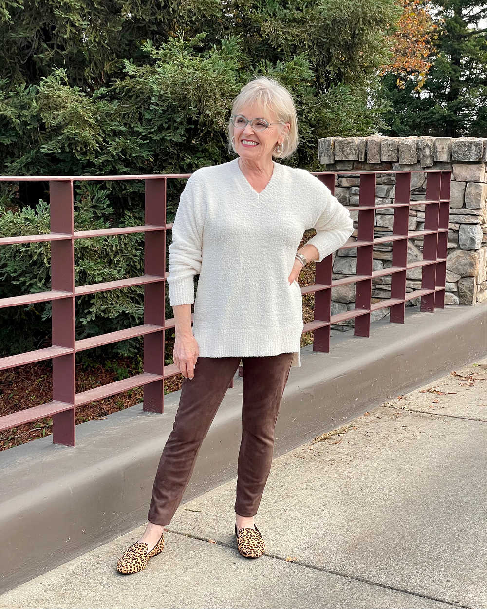 blonde woman wearing ivory sweater brown leggings and cheetah print flats