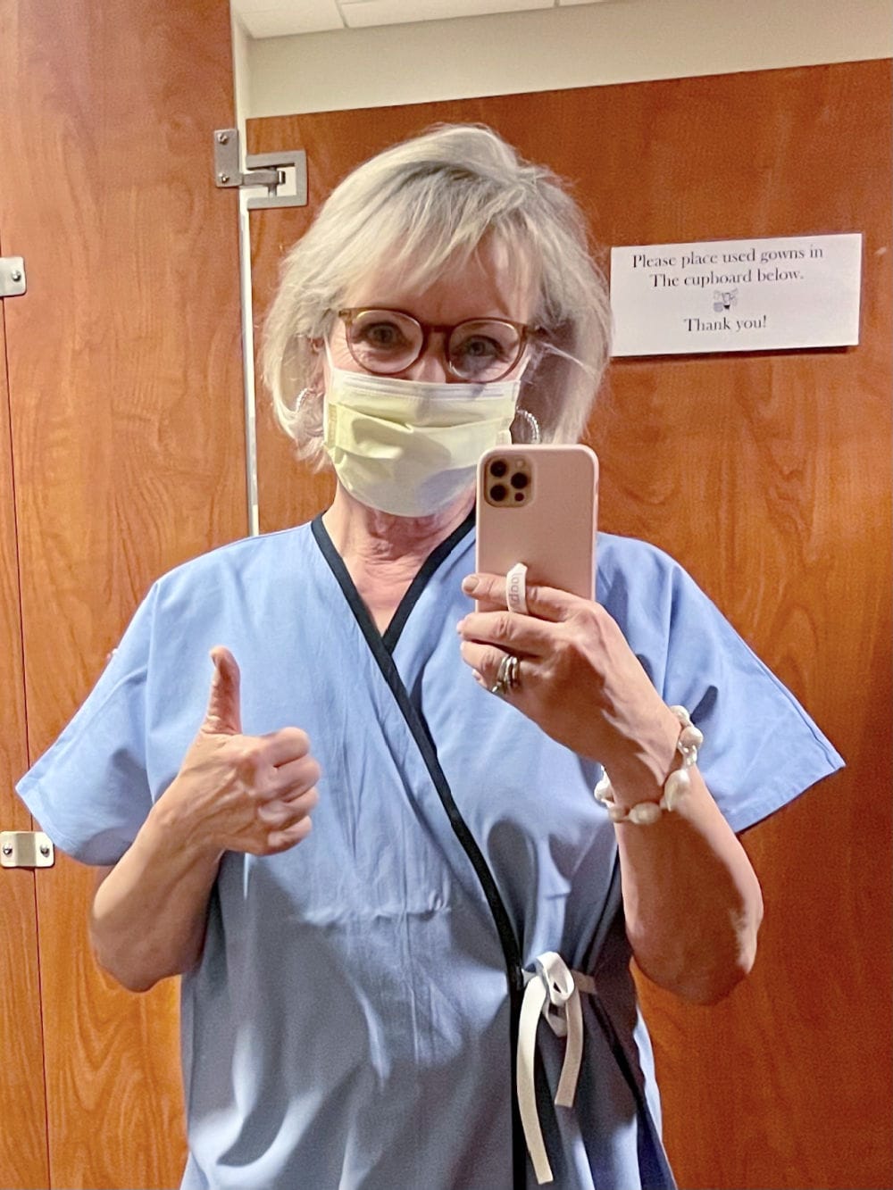woman wearing blue gown awaiting her mammogram appointment