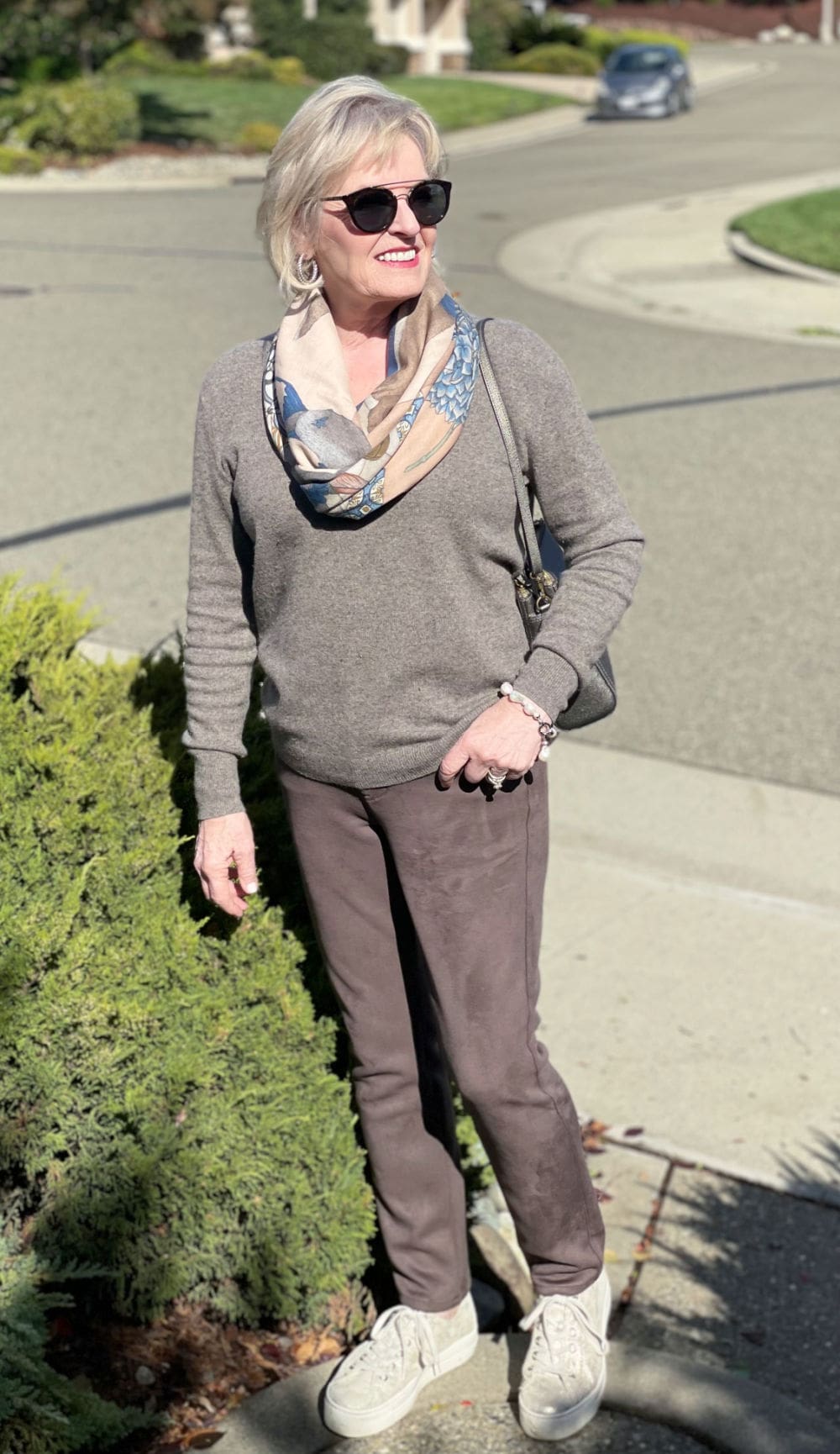 woman wearing cashmere, sneakers and pearls