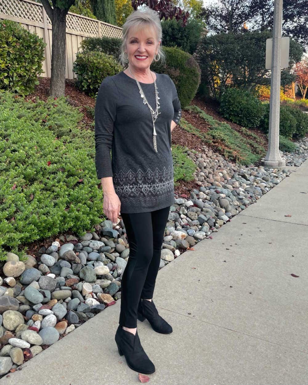 woman standing on sidewalk wearinjg leggings and embrooidered tunic top