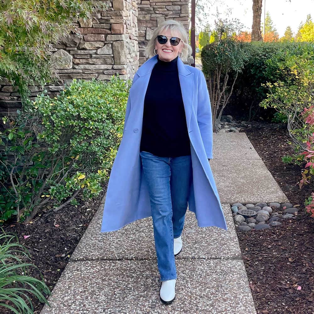 woman walking in blue coat and jeans