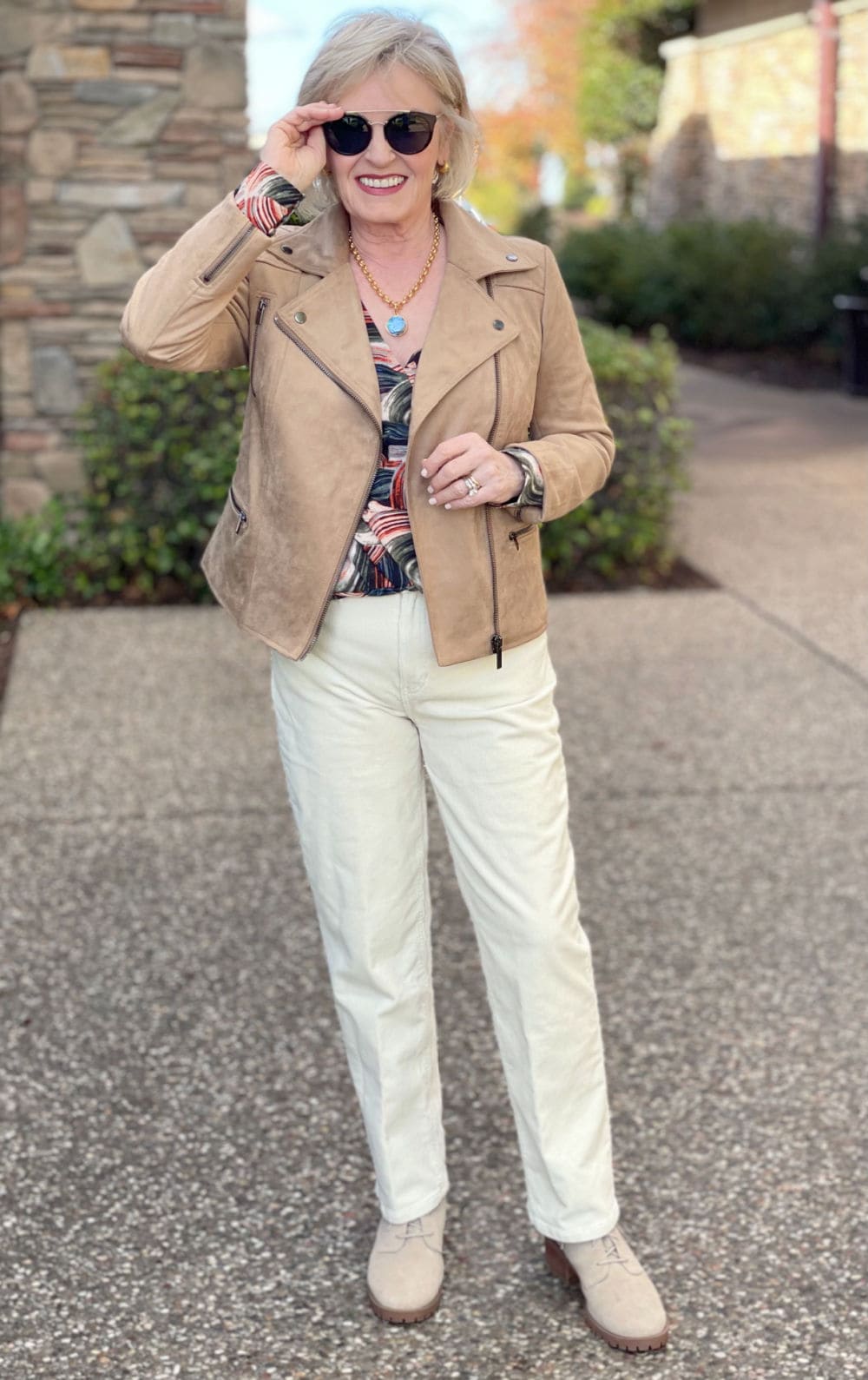 blonde woman wearing cream pants and taupe jacket