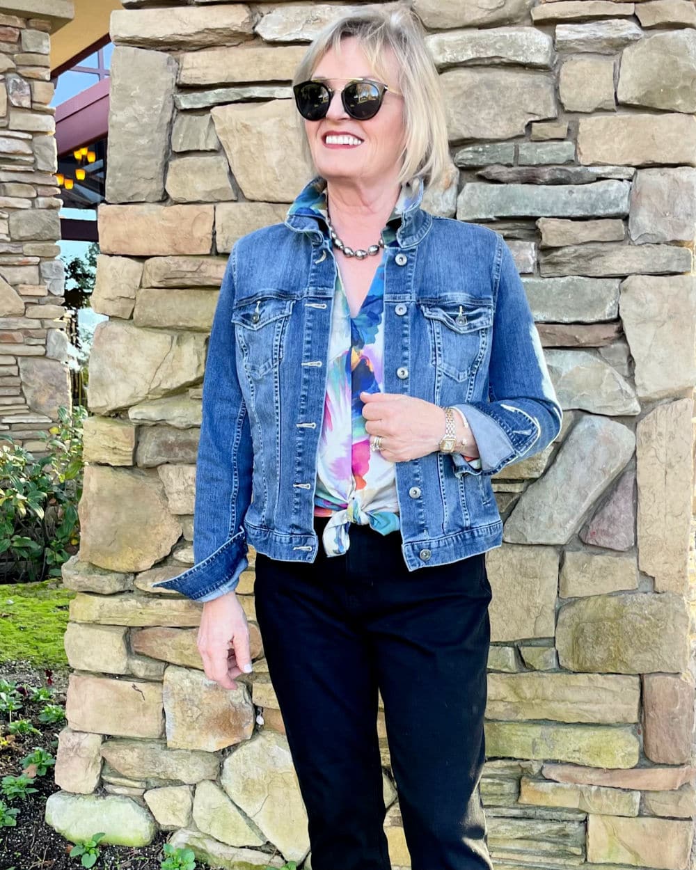 woman wearing floral blouse and denim jacket