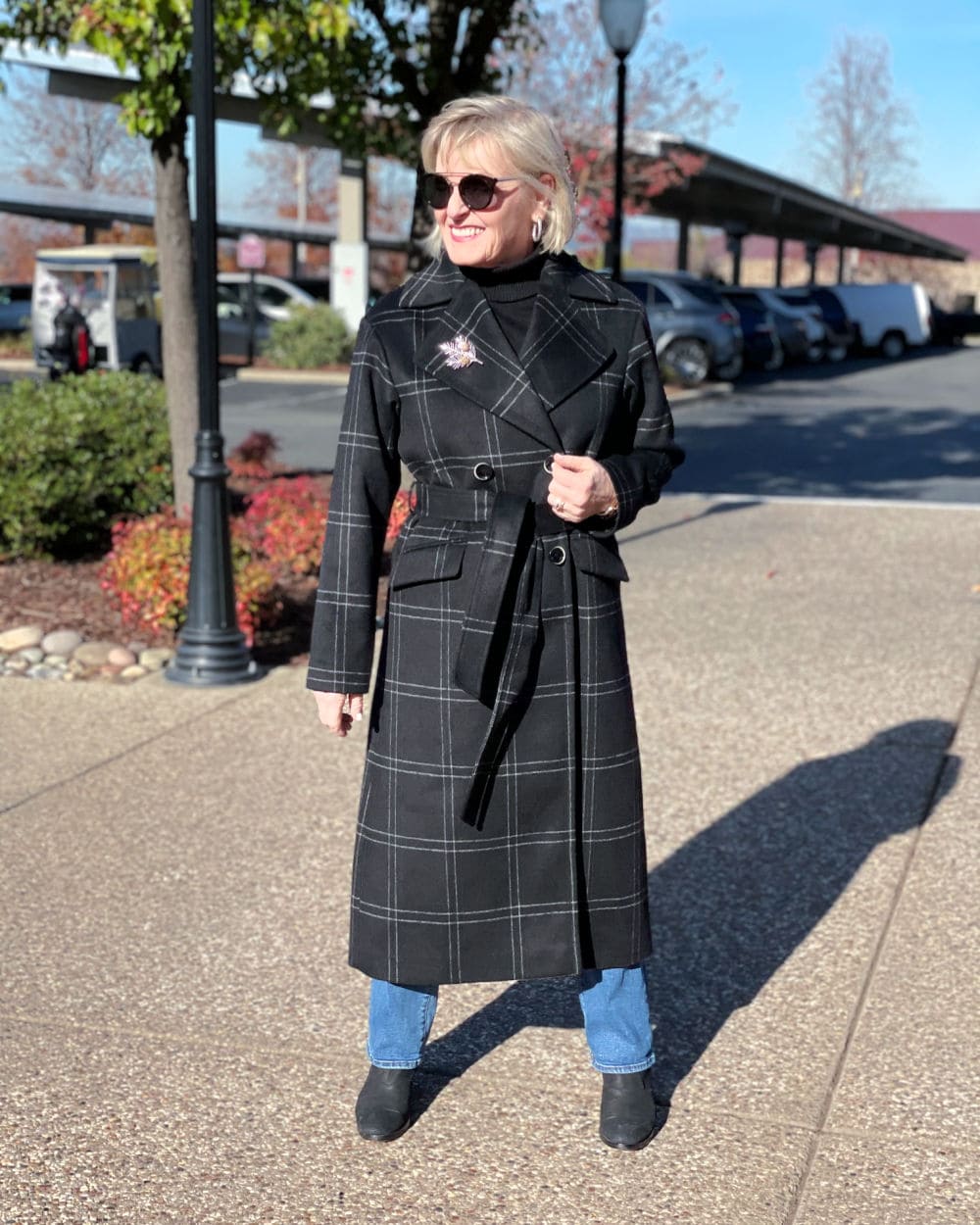 blonde woman wearing plaid coat and jeans