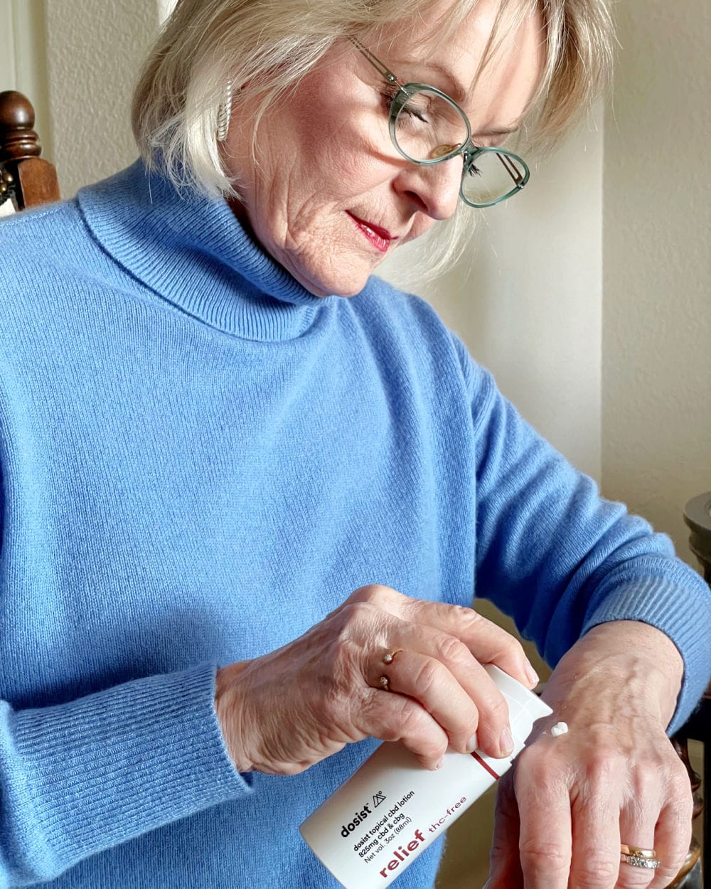 woman applying dosist relief cream to back of hand