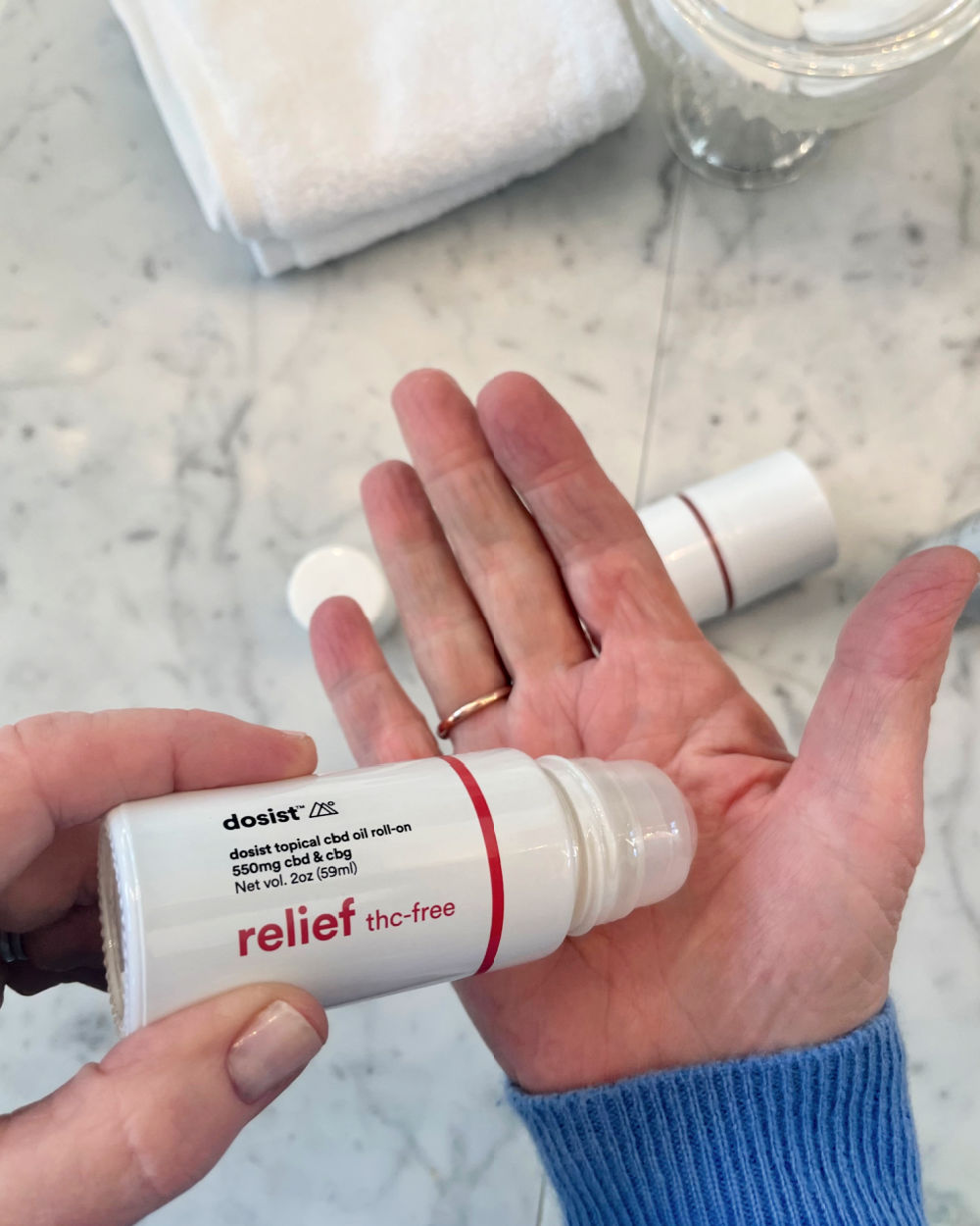 applying dosist roll on to palm of hand