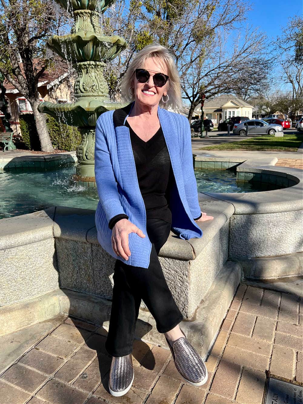 WOMAN SITTING ON FOUNTAIN EDGE