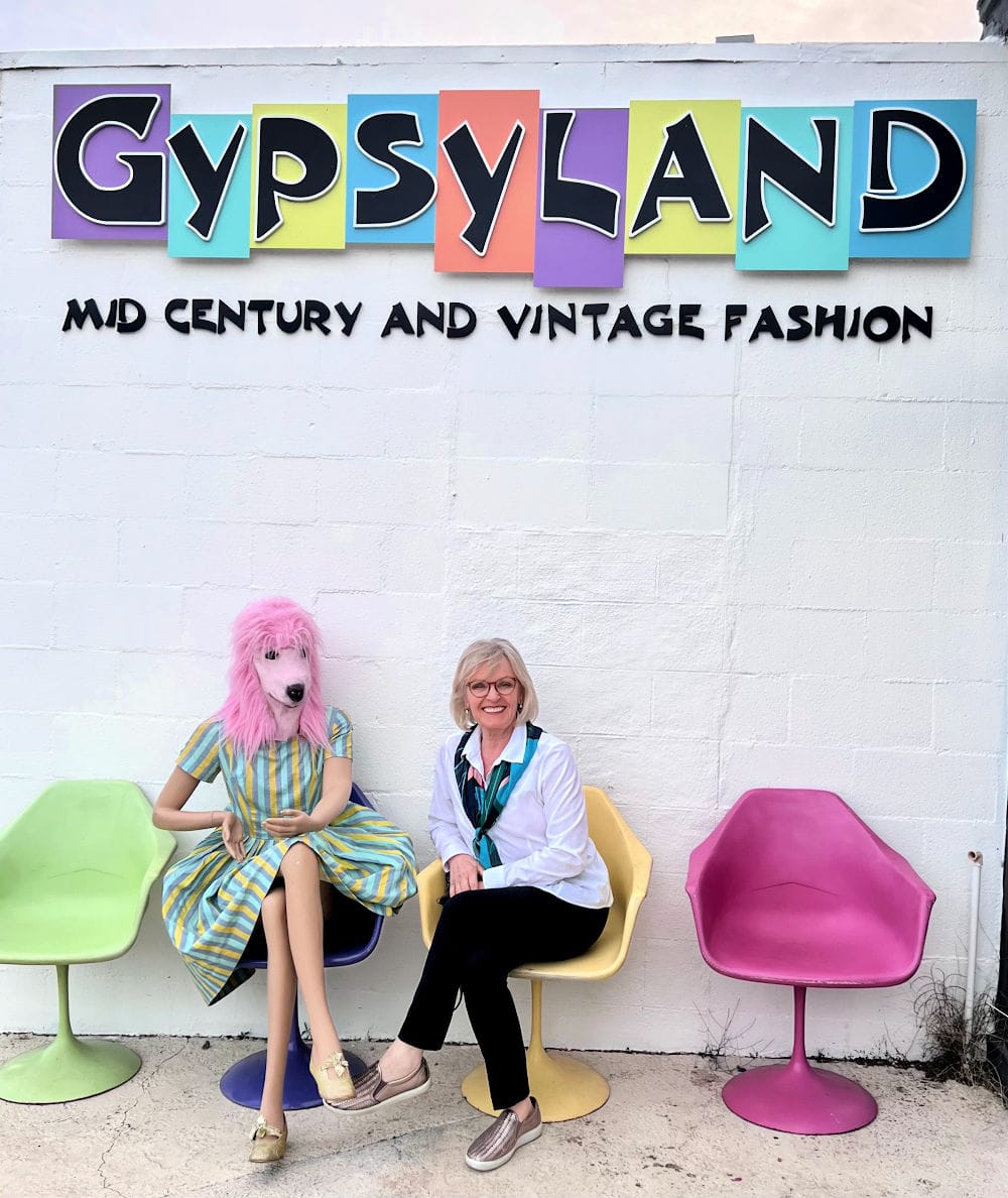 woman sitting under gysyland sign