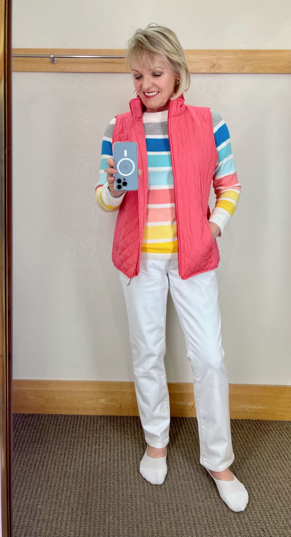 WOMAN WEARING PINK VEST STRIPED SWEATER AND WHITE JEANS