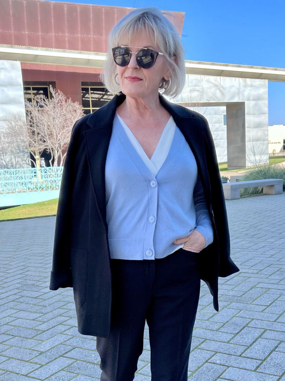 woman wearing blue sweater and black knit jacket