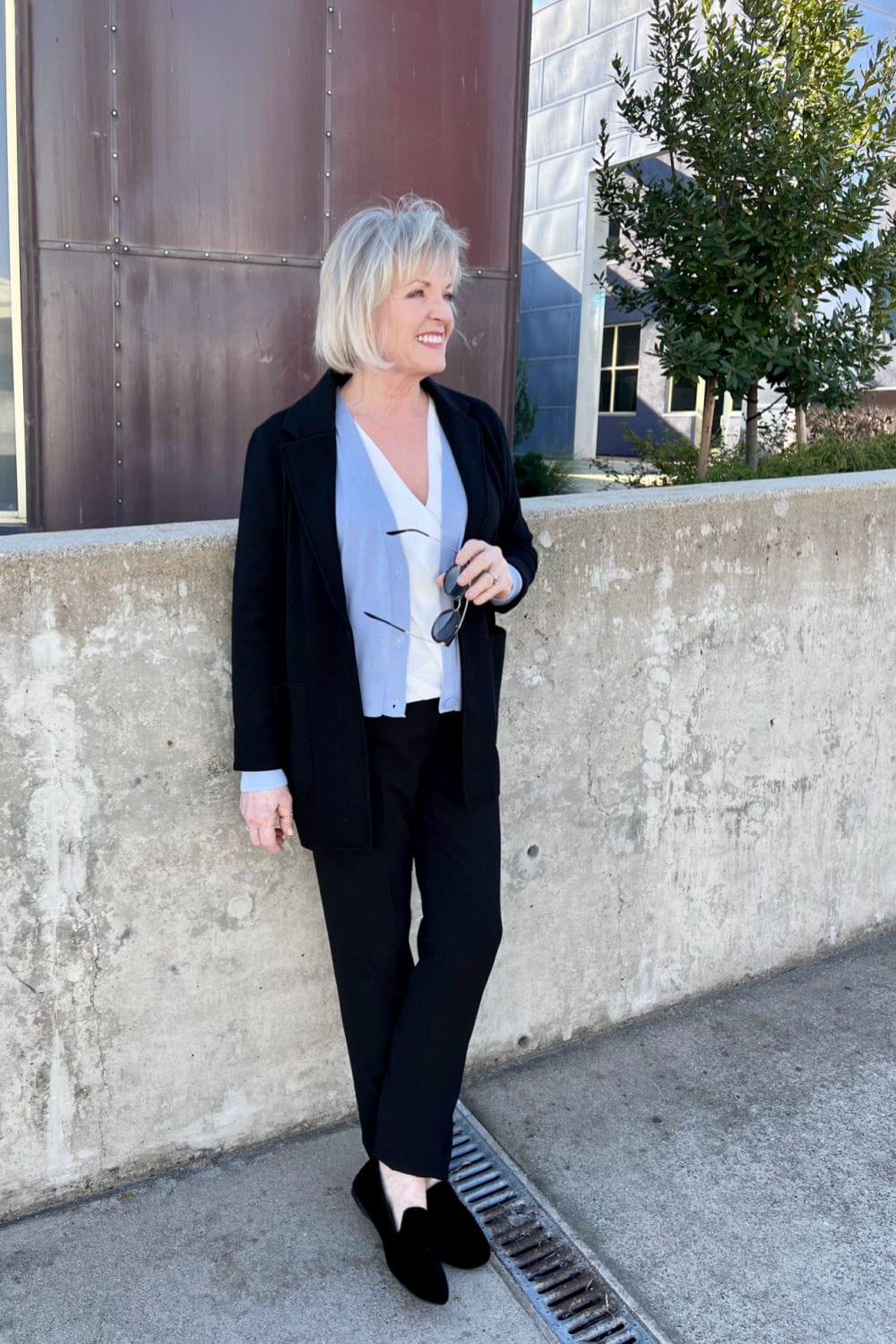 woman leaning on wall wearing classic blue and black outfit