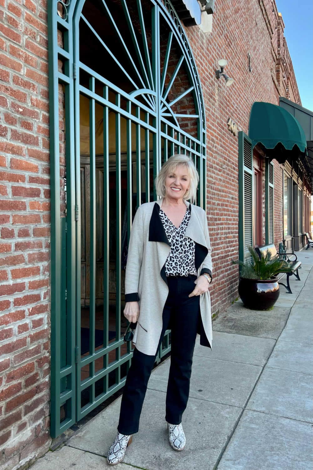 woman wearing black jeans and leopard blouse