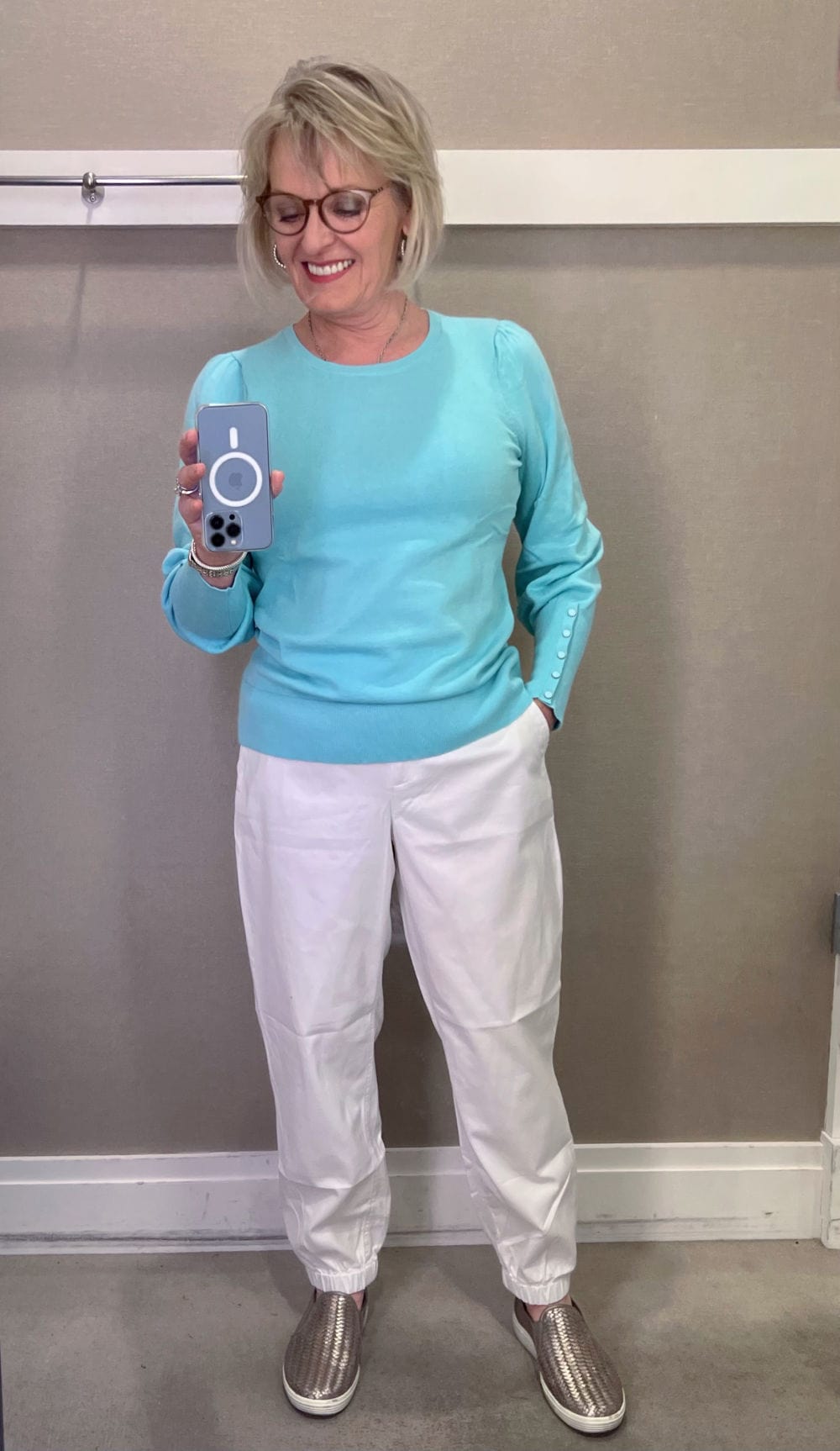 woman wearing aqua sweater and white pants