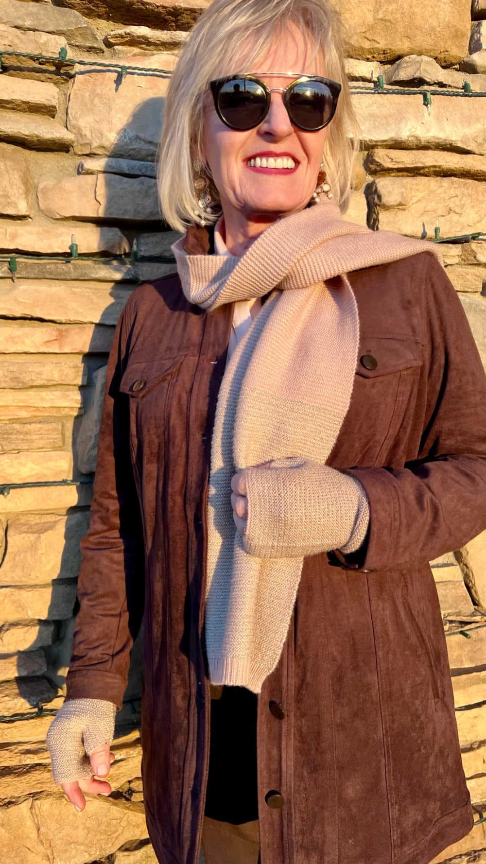blonde woman wearing brown jacket and pink scarf