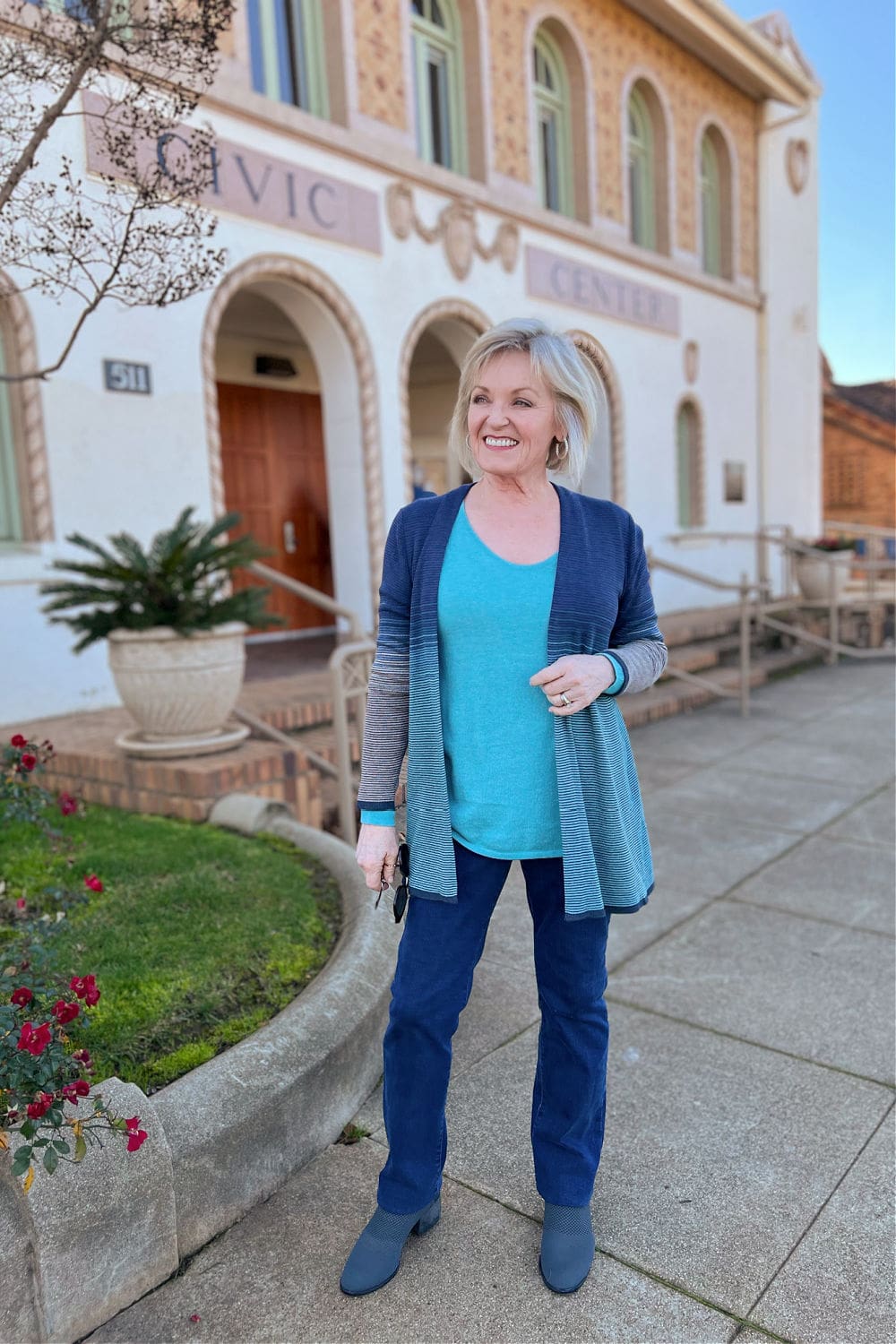 blonde woman wearing turqoise sweater for wardrobe refresh