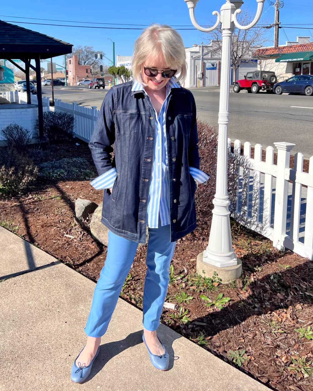 elongated denim jacket with blue pants and striped shirt